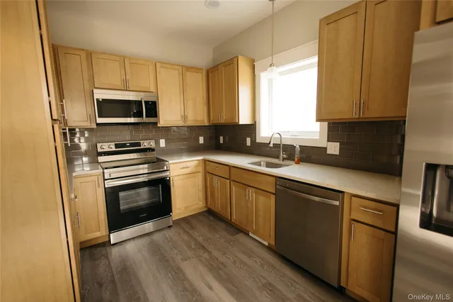 a kitchen with a sink a microwave a stove and cabinets