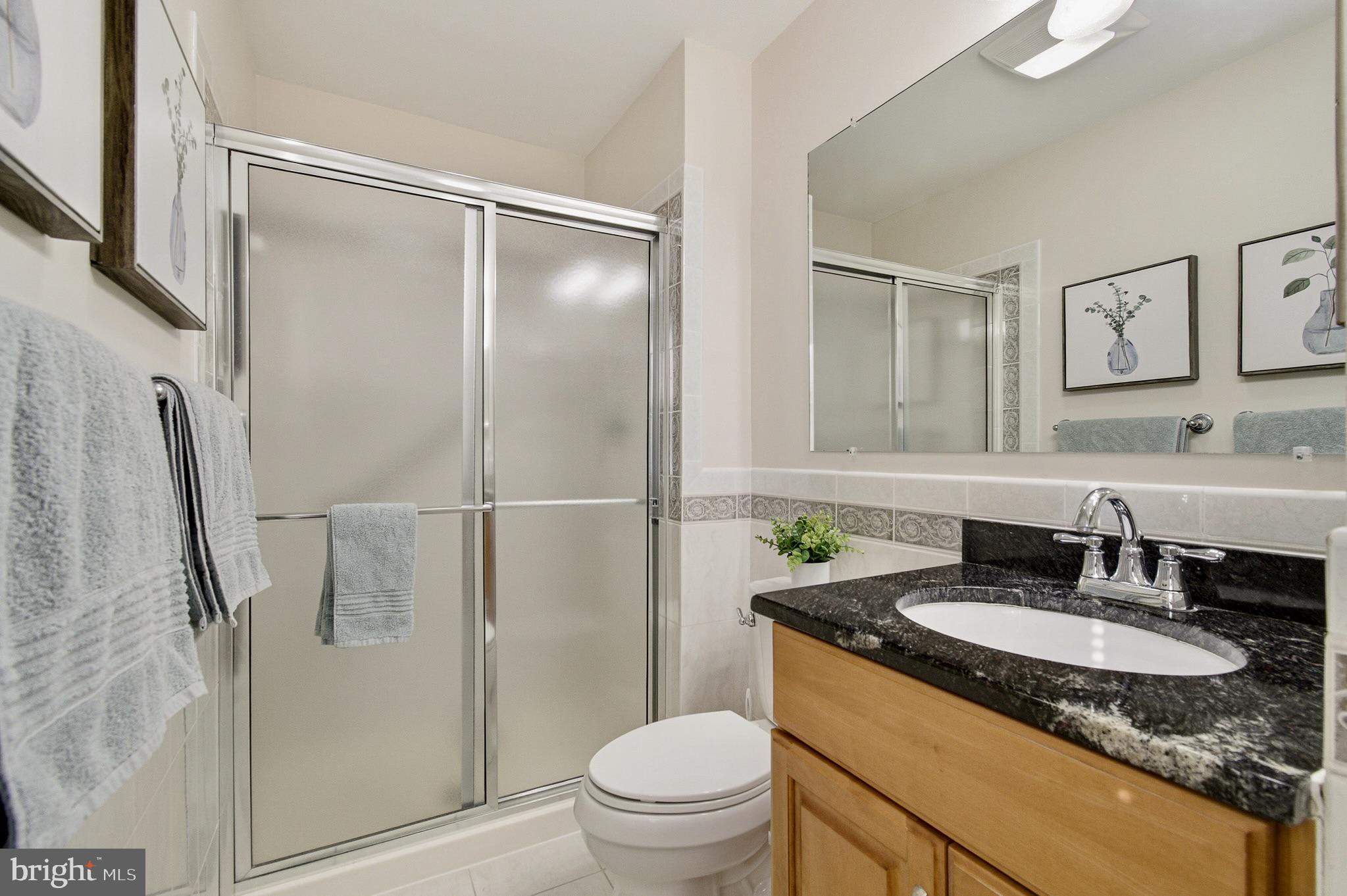 4705 Ilkley Moor Lane Ellicott City, MD 21043 - Photo 33 of 69 a bathroom with a granite countertop sink toilet and shower