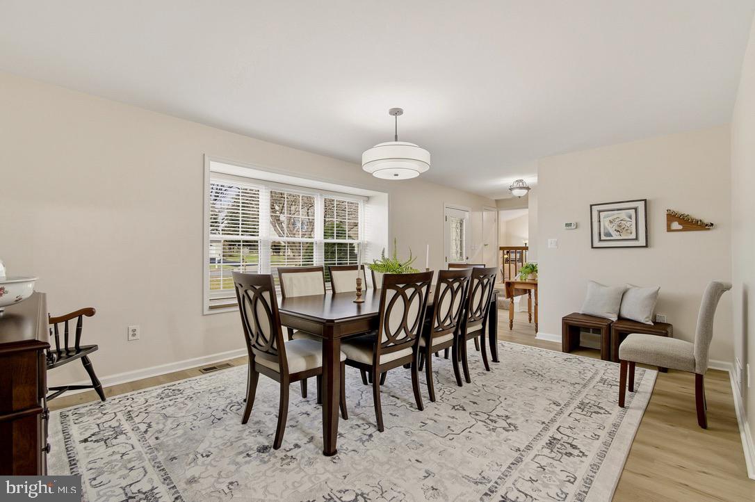 4705 Ilkley Moor Lane Ellicott City, MD 21043 - Photo 5 of 69 a dining room with furniture a rug and a chandelier