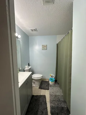 a bathroom with a toilet sink and a mirror