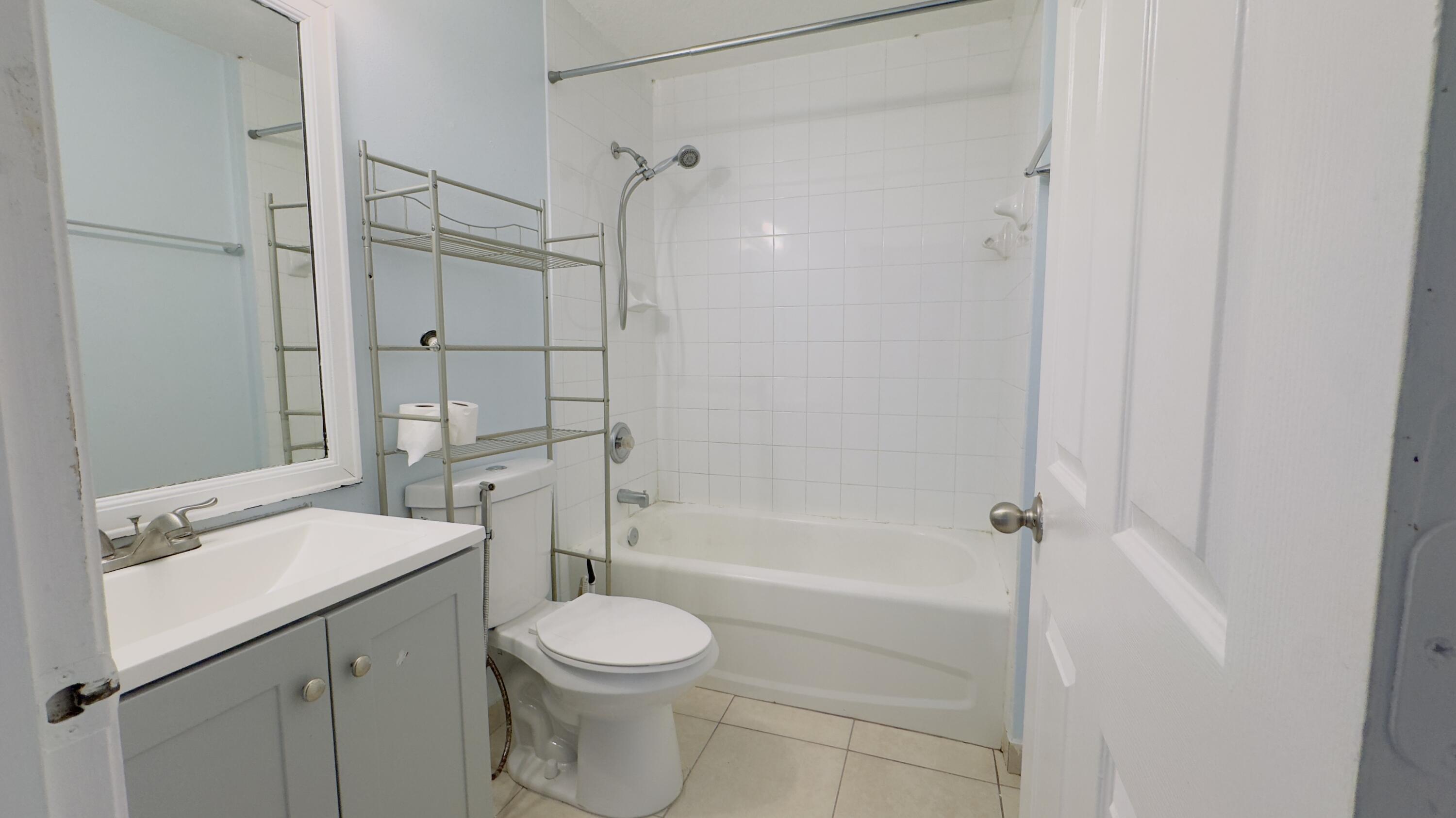 3481 Briar Bay Boulevard, Unit 201 West Palm Beach, FL 33411 - Photo 19 of 19 a bathroom with a sink a toilet and shower