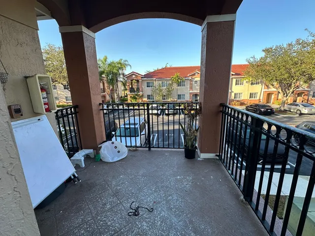 a view of a porch with furniture and floor to ceiling window