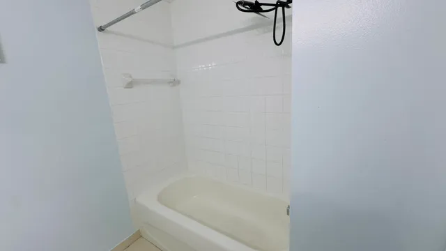 a bathroom with a bath tub with a shower