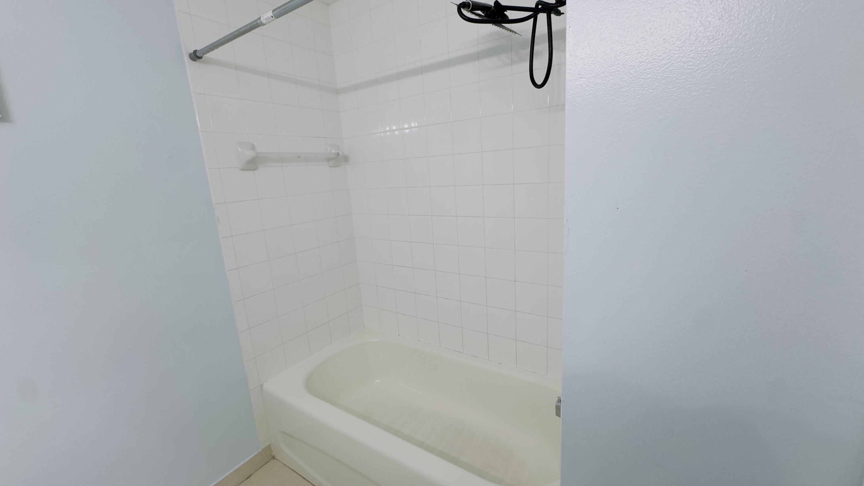 3481 Briar Bay Boulevard, Unit 201 West Palm Beach, FL 33411 - Photo 5 of 19 a bathroom with a bath tub with a shower