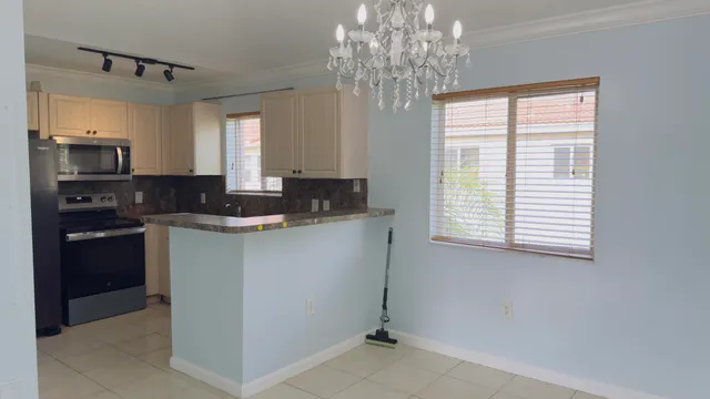 a kitchen with granite countertop a sink stainless steel appliances and a window