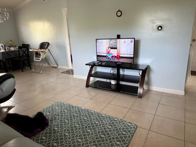 a living room with furniture a flat screen tv and gym equipment