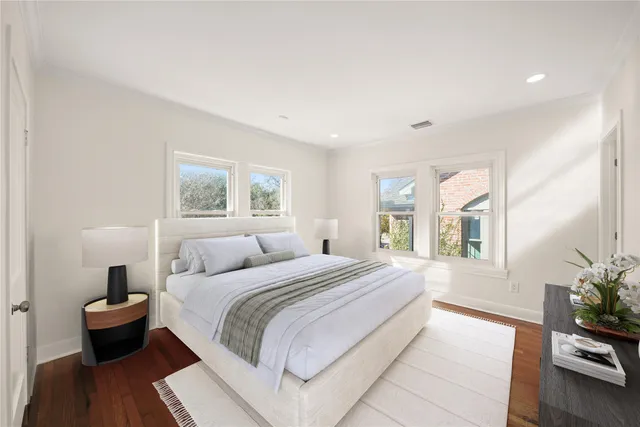 a bedroom with a large bed and a potted plant