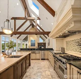 a large kitchen with stainless steel appliances granite countertop a sink and stove top oven