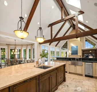 a kitchen with stainless steel appliances granite countertop a sink and a large window