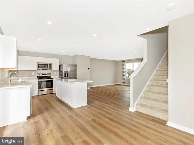 a view of kitchen with wooden floor and electronic appliances