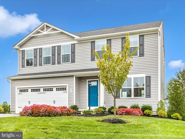 a front view of a house with a garden and yard