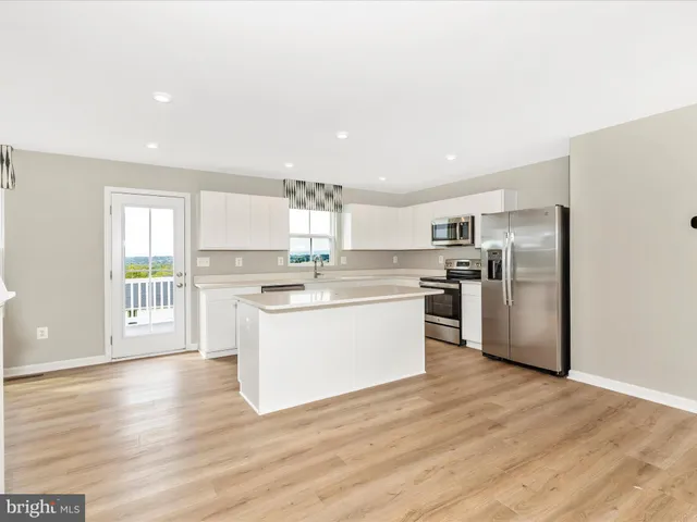 a kitchen with a refrigerator and white cabinets