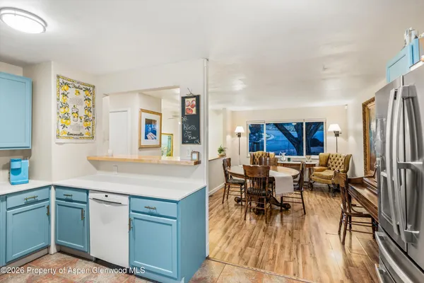 a dining hall with stainless steel appliances granite countertop a stove and a dining table