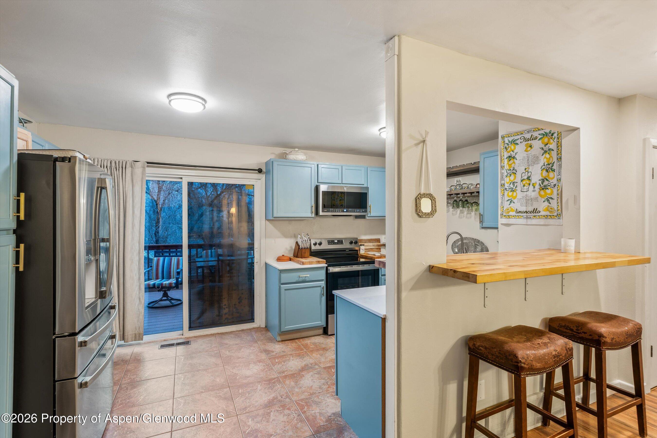 805 Munro Avenue Rifle, CO 81650 - Photo 4 of 23 a kitchen with stainless steel appliances granite countertop a refrigerator and a stove top oven