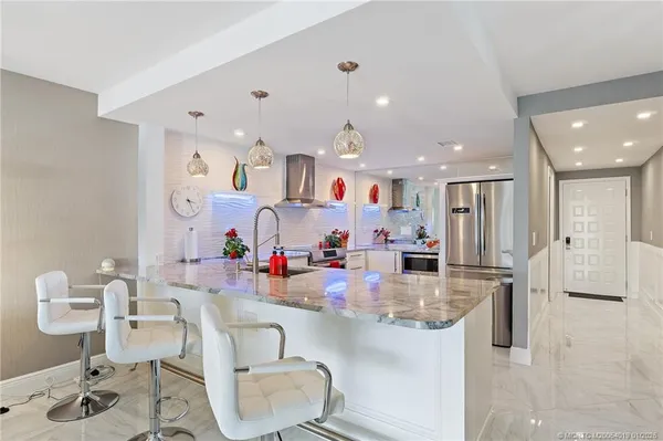 a kitchen with stainless steel appliances kitchen island granite countertop a sink and cabinets