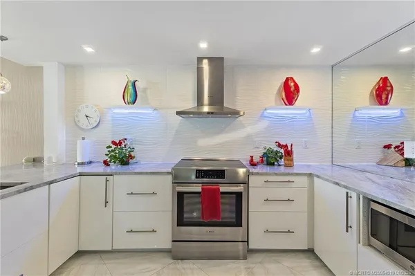 a room with stainless steel appliances kitchen island furniture and a view of kitchen