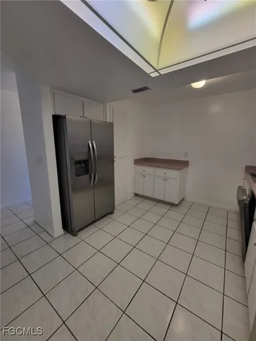a view of a refrigerator and more cabinets in a room