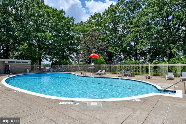 a front view of multi story residential apartment building with yard and parking space