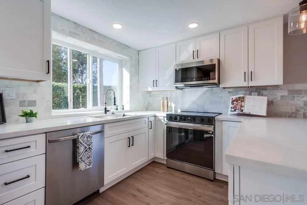1278 Avenida Miguel Encinitas, CA 92024 - Photo 18 of 47 a kitchen with granite countertop white cabinets and stainless steel appliances