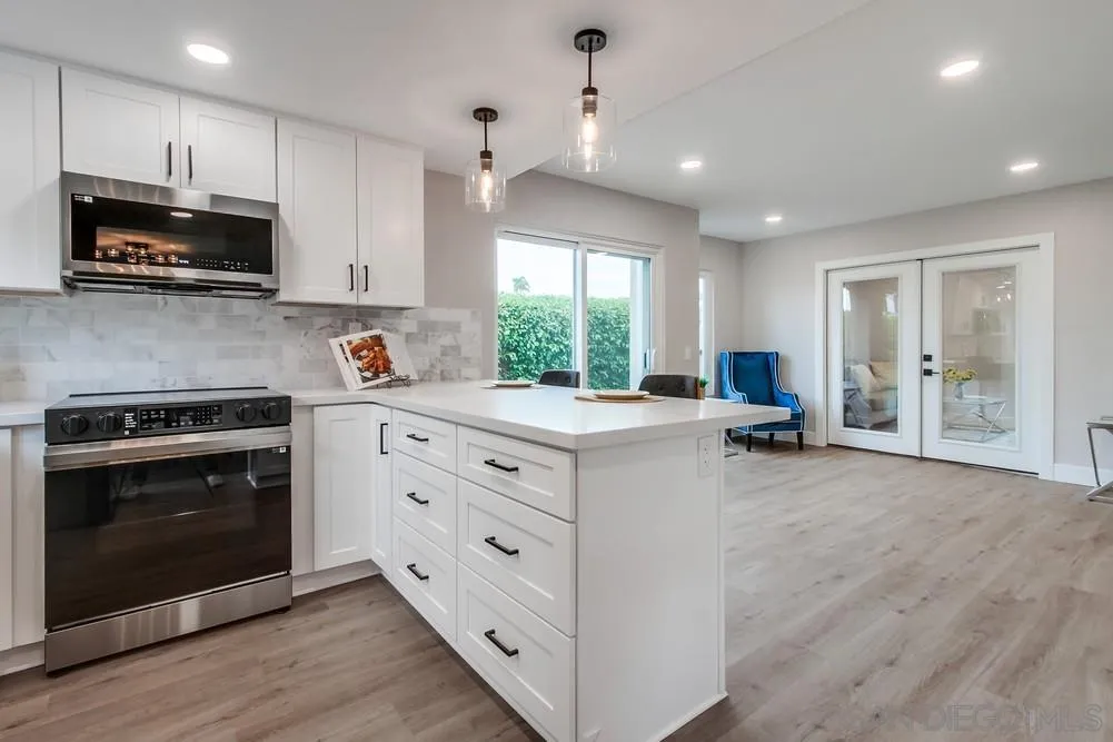 1278 Avenida Miguel Encinitas, CA 92024 - Photo 21 of 47 a kitchen with kitchen island granite countertop white cabinets and stainless steel appliances