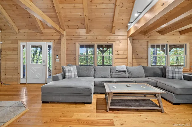 a living room with furniture a wooden floor and a large window