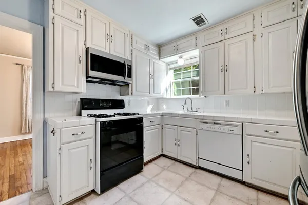 a kitchen with white cabinets and white appliances