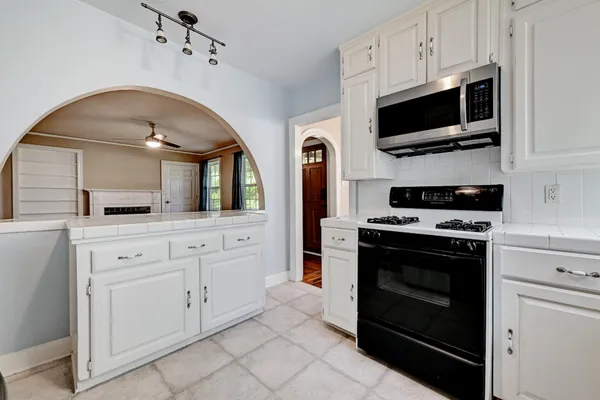 a kitchen with white cabinets and stainless steel appliances