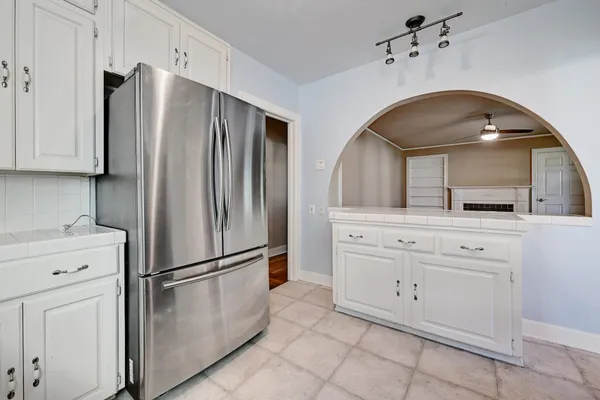 a kitchen with white cabinets and stainless steel appliances