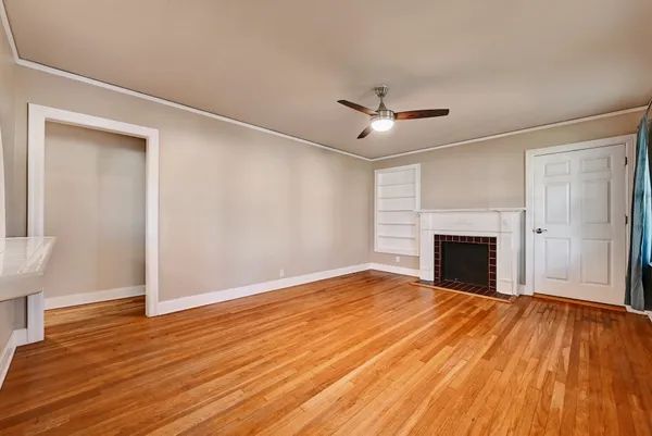 a view of empty room with wooden floor and fireplace