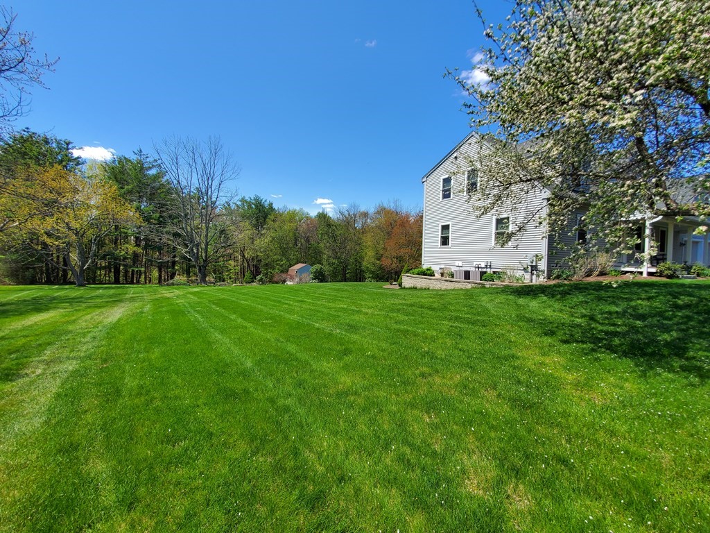 12 Beaman Road Sterling, MA 01564 - Photo 5 of 40 a white house with a big yard and large trees