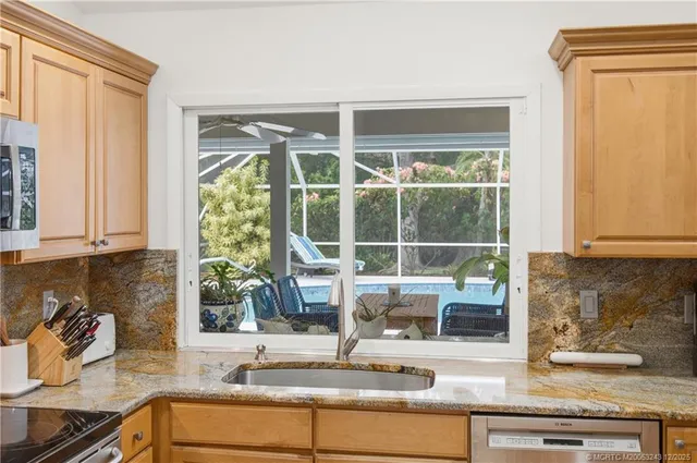 a kitchen with stainless steel appliances granite countertop a refrigerator stove and sink