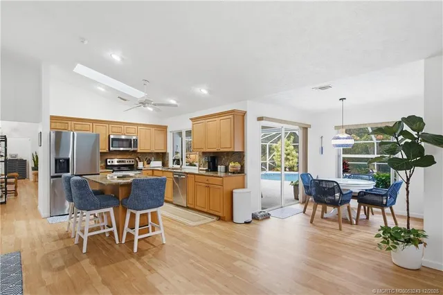 a living room with furniture a dining table and chairs with kitchen appliances