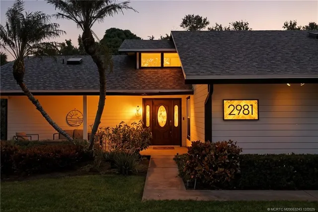 a view of a brick house with a large window and a yard