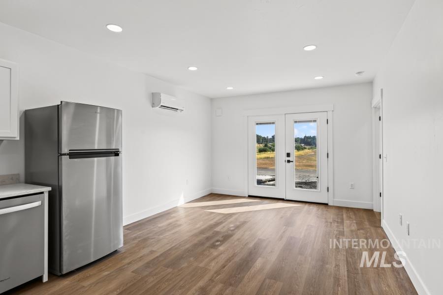 1298 Edington Moscow, ID 83843 - Photo 27 of 32 Stainless steel refrigerator, wood-finish flooring, recessed lighting, white walls, and French doors