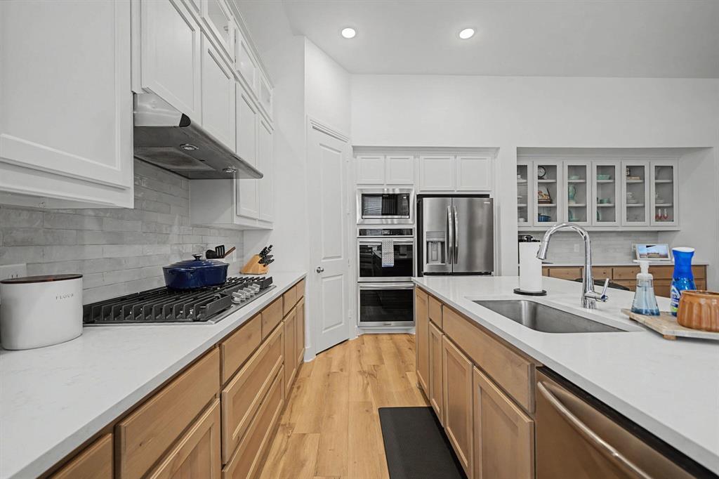 1228 Emilia Road Fate, TX 75087 - Photo 11 of 31 a kitchen with stainless steel appliances a sink stove and cabinets