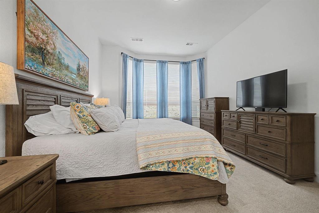 1228 Emilia Road Fate, TX 75087 - Photo 15 of 31 a bedroom with a bed and flat screen tv