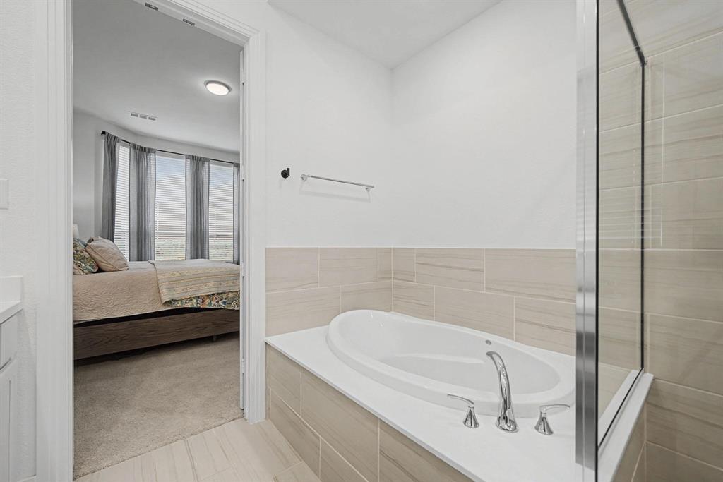 1228 Emilia Road Fate, TX 75087 - Photo 18 of 31 a en suite bathroom with a tub and large window