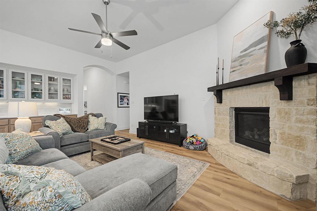 1228 Emilia Road Fate, TX 75087 - Photo 6 of 31 a living room with furniture a flat screen tv and a fireplace