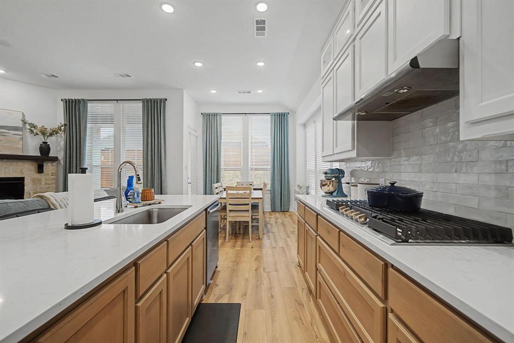 1228 Emilia Road Fate, TX 75087 - Photo 10 of 31 a kitchen with stainless steel appliances a sink stove and cabinets
