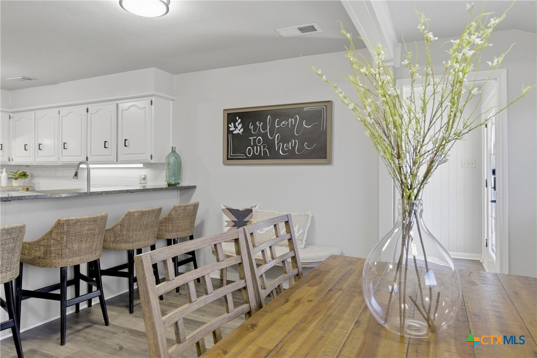 1710 Old Mill Road, Unit 12 Salado, TX 76571 - Photo 14 of 42 a view of a dining room with furniture and wooden floor
