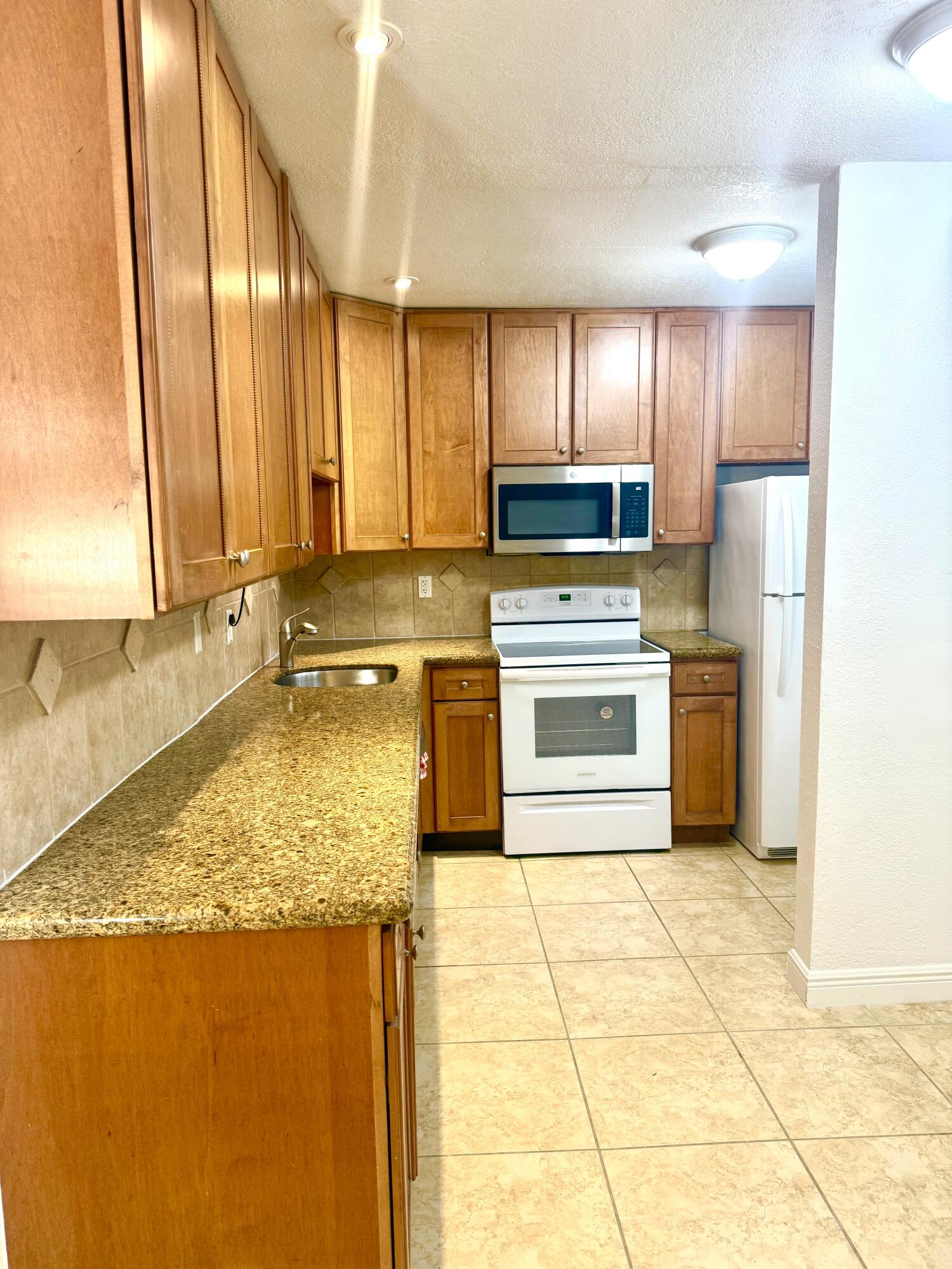 a kitchen with a stove a sink and a refrigerator