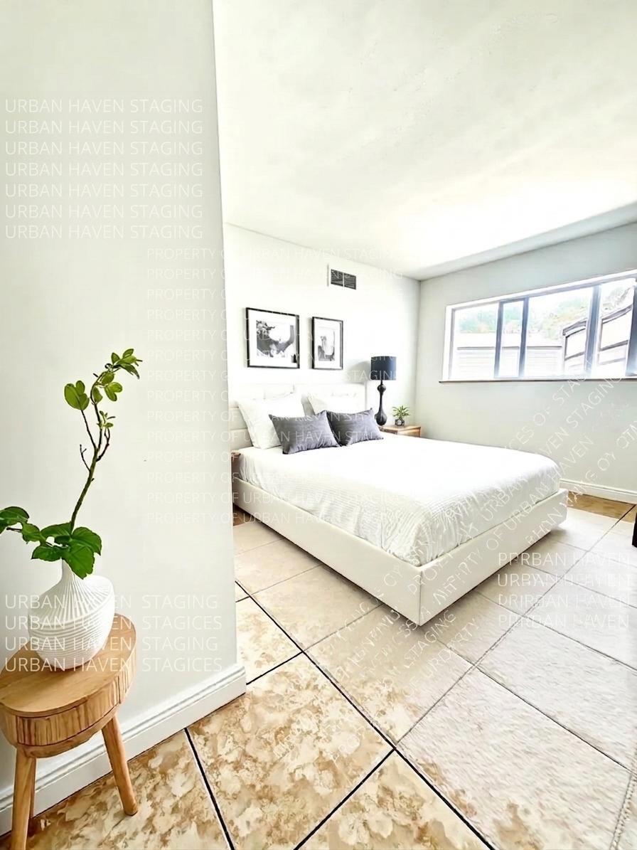 199 East McNab Road, Unit 109 Pompano Beach, FL 33060 - Photo 7 of 17 a bedroom with a bed and a potted plant