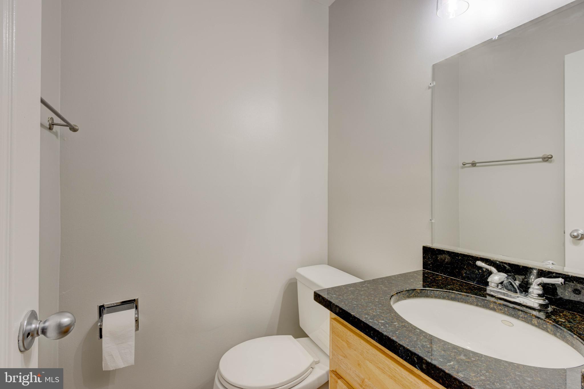 3934 Chesterwood Drive, Unit 3934 Silver Spring, MD 20906 - Photo 13 of 26 a bathroom with a granite countertop toilet sink and mirror