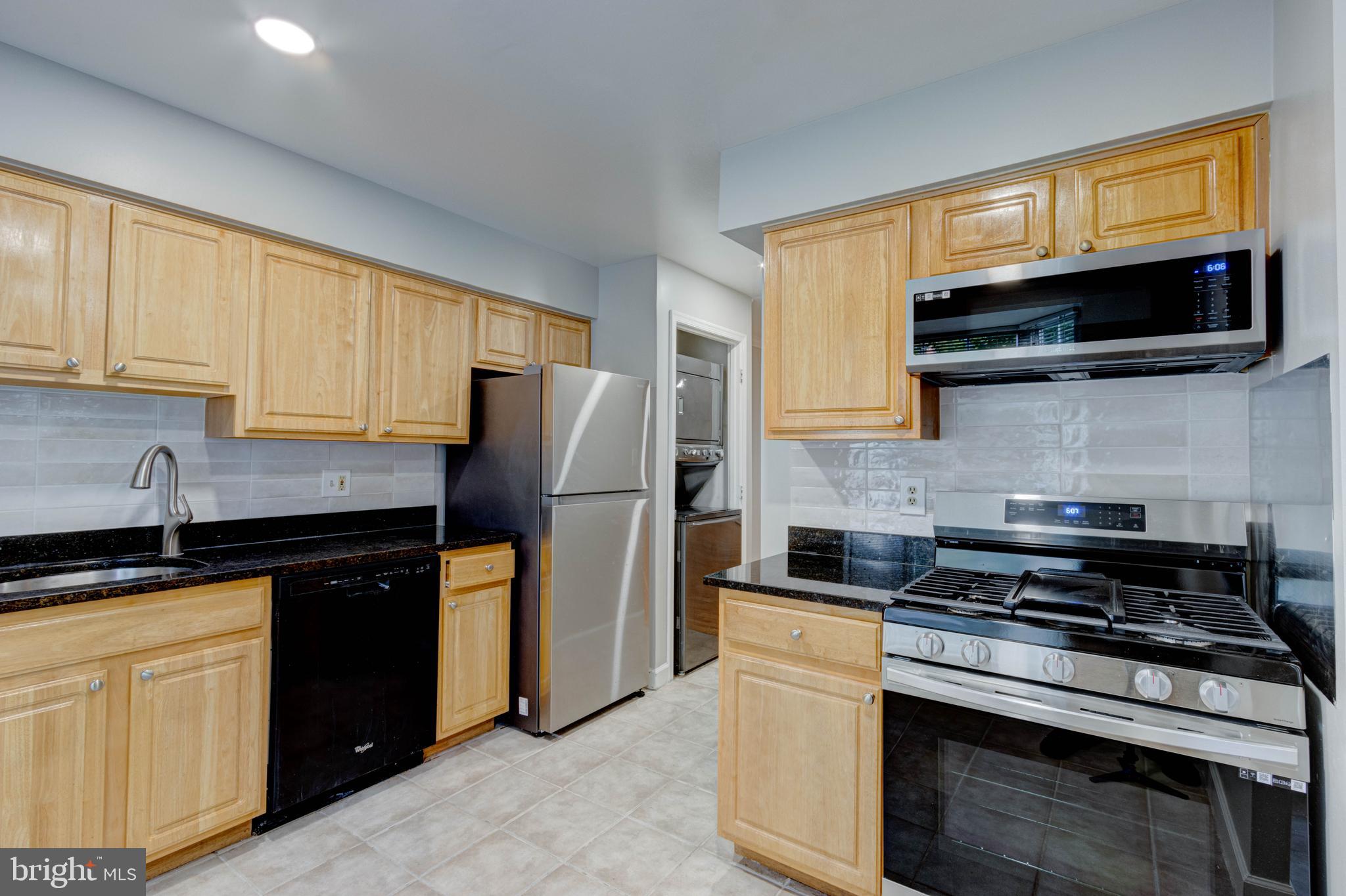 3934 Chesterwood Drive, Unit 3934 Silver Spring, MD 20906 - Photo 5 of 26 a kitchen with stainless steel appliances granite countertop a stove microwave and refrigerator