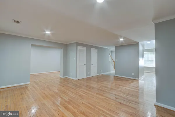a view of an empty room with wooden floor and closet
