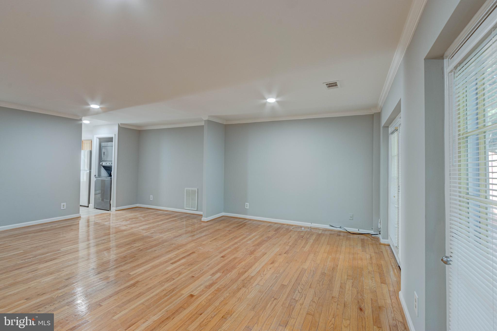 3934 Chesterwood Drive, Unit 3934 Silver Spring, MD 20906 - Photo 10 of 26 a view of an empty room with wooden floor and a window