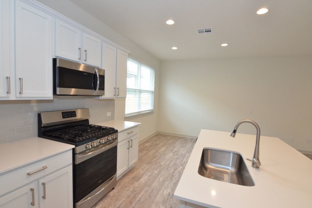428 Agave Azul Way Leander, TX 78641 - Photo 11 of 24 Clean lines and a spacious layout define this modern culinary workspace with recessed lighting.