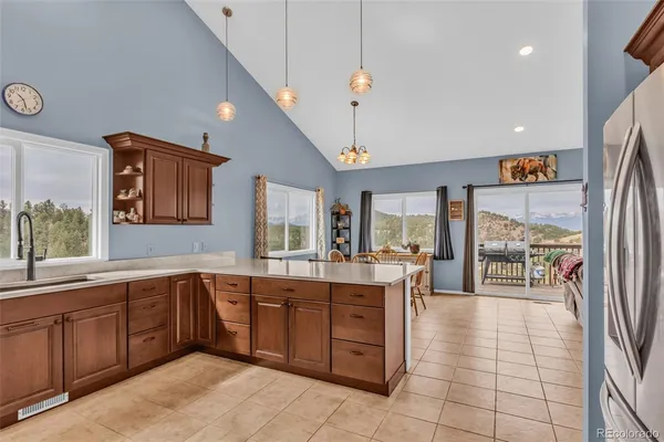 a kitchen with a sink and a large mirror next to a window