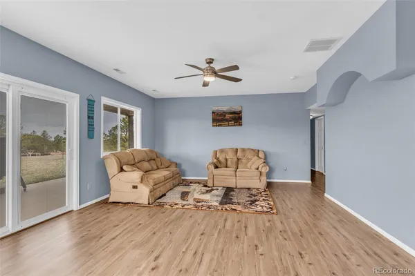 a living room with furniture and a wooden floor