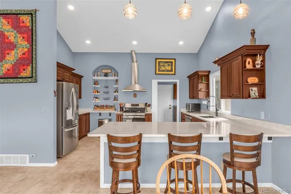 a kitchen with stainless steel appliances granite countertop a stove top oven a sink dishwasher and a refrigerator